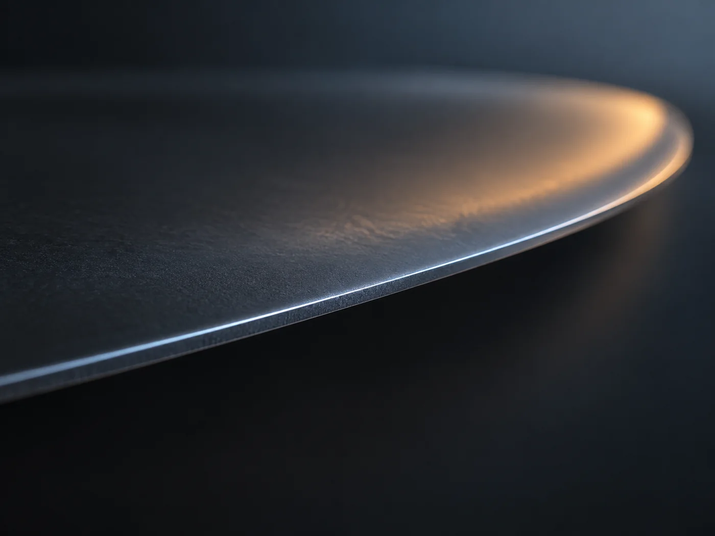 Conceptual image of a thin dark film curving gently against a dark background, with a soft streak of light running along its edge