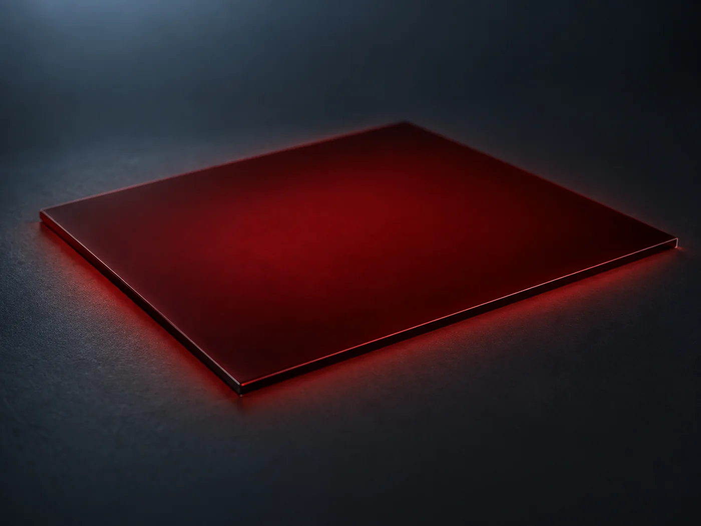 Conceptual image, from a low angle against a dark background, of a soft, even deep-red glow seeping from the surface of a flat dark brown film
