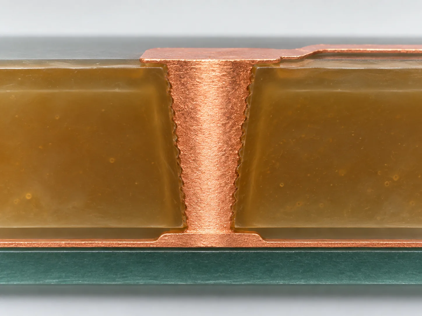Macro impression of a tiny laser-drilled hole in a resin layer filled with plated copper, connecting the wiring layers above and below